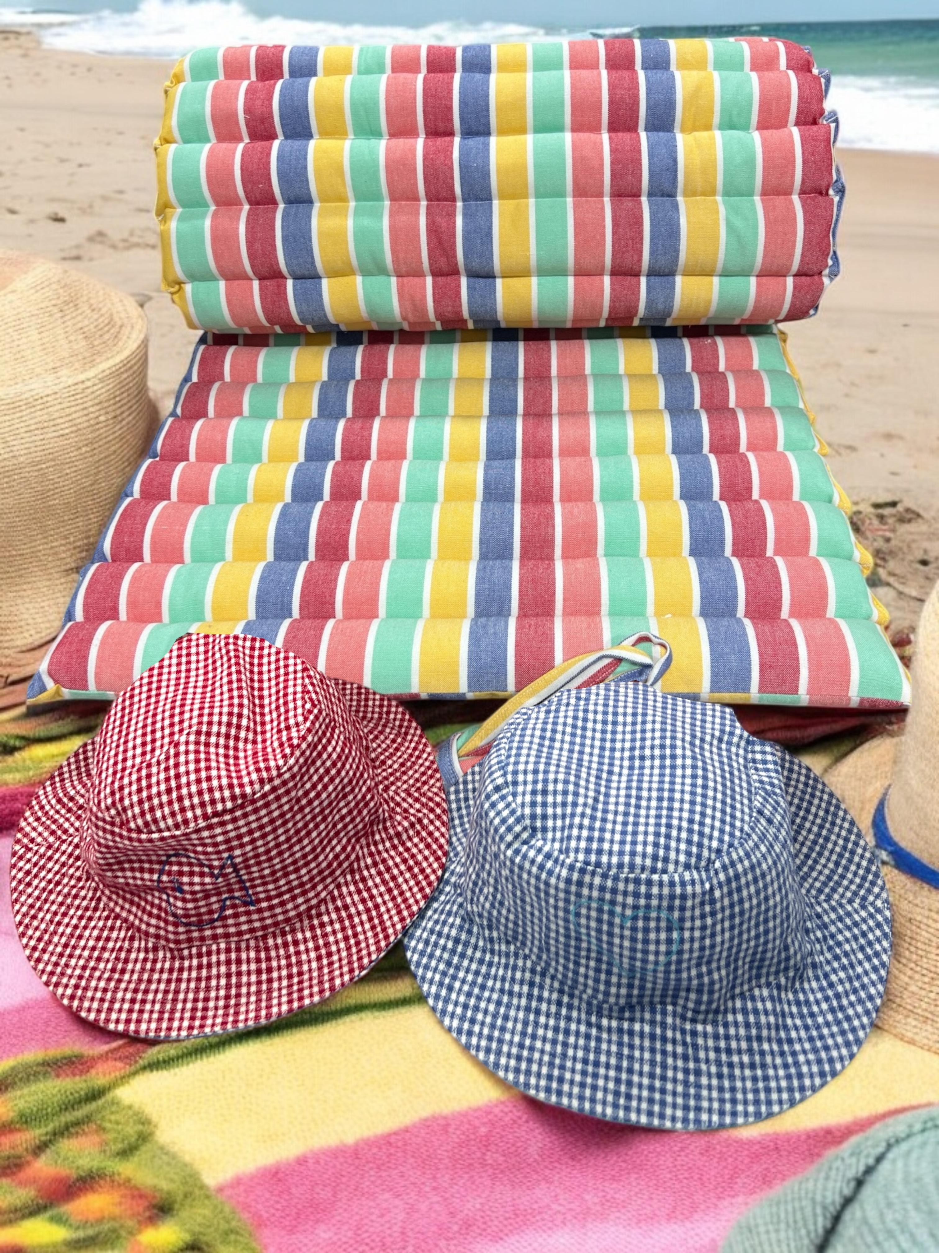 Colorful beach mats and sun caps on a sandy beach